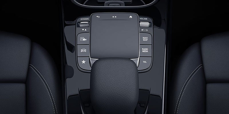 Overhead view of a car's center console with black leather seats, a gear shifter, and an infotainment system