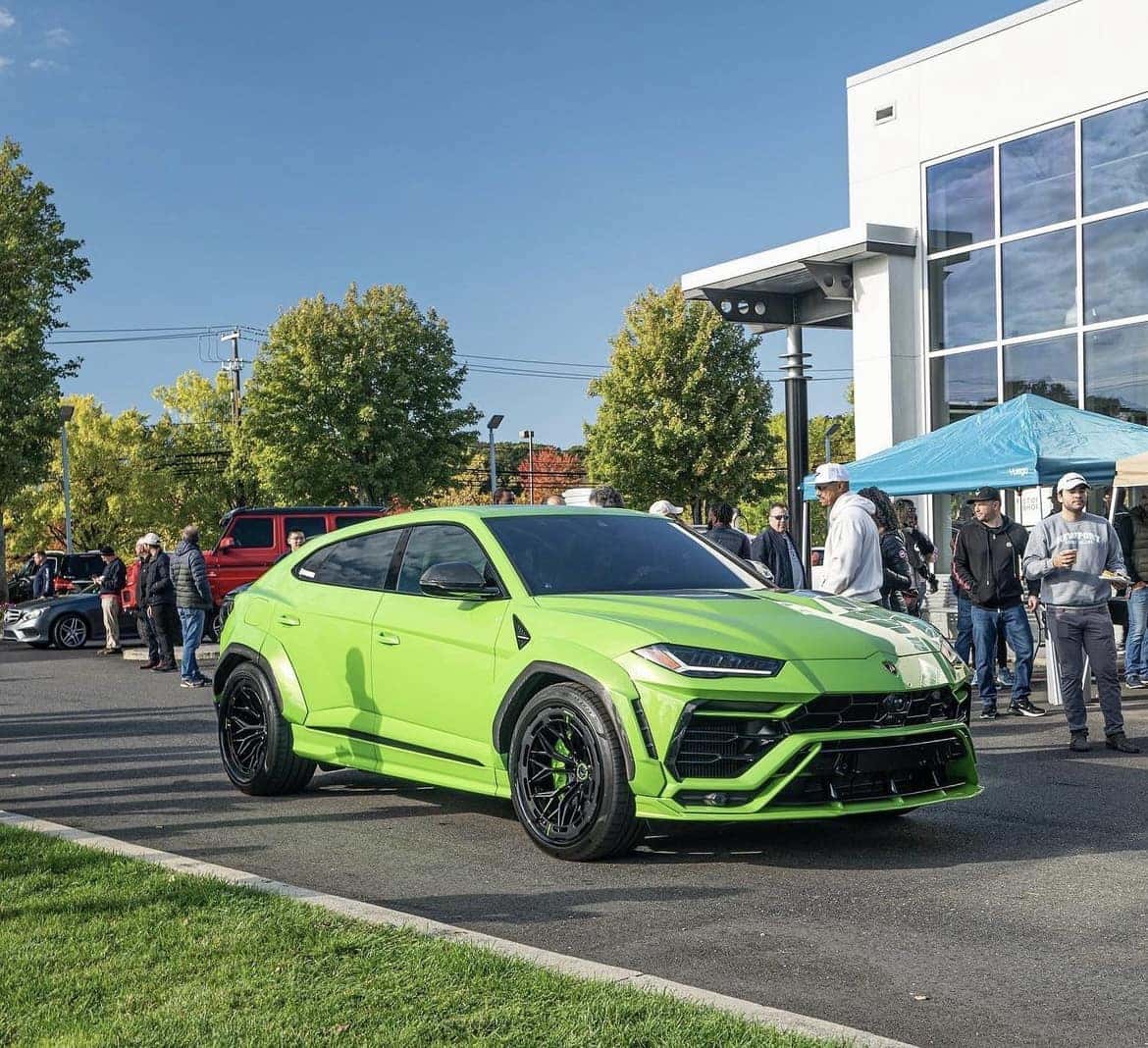 Bright green widebody Lamborghini Urus on display in front of the dealership