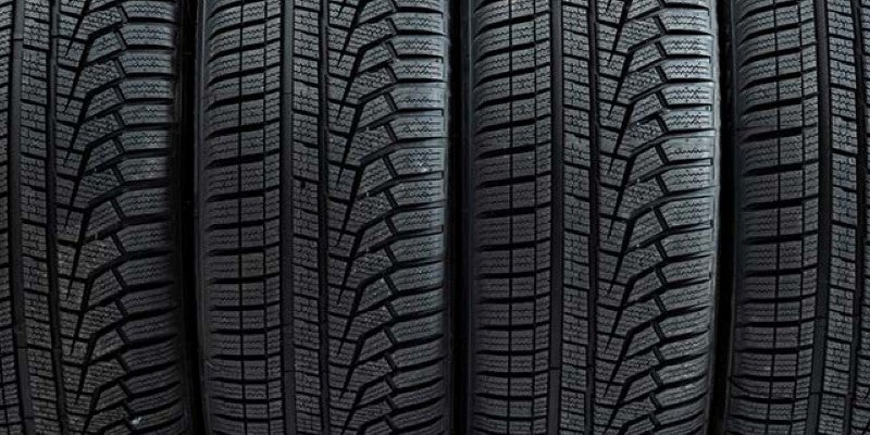 Close-up view of several black vehicle tires positioned side by side, showing detailed tread patterns and grooves